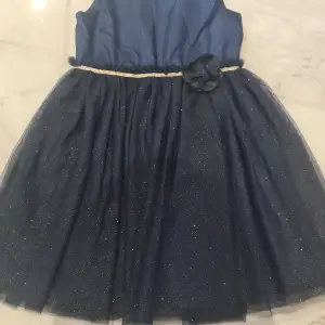Jag säljer en vacker marinblå festklänning med glitter på. Använd ett par gånger men klänningen har inga skråmor! Klänningen är till barn. Klicka gärna på köp nu!💗