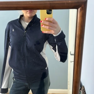 Ralph Lauren tröja - En tjockare tröja från Ralph Lauren. Väldigt skönt material och väldogt bra skick. Fickor med dragkedja. Den är liten i storleken, passar mig som brukar ha M. 