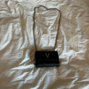 Valentino väska - Det är en super fin väska från valentino bags. Den är lite rostig (kolla bild 3) den har även tappat en metall sak men man märker inte det och det ser inte konstigt ut. Köpt för ca 600 säljer för 200. 