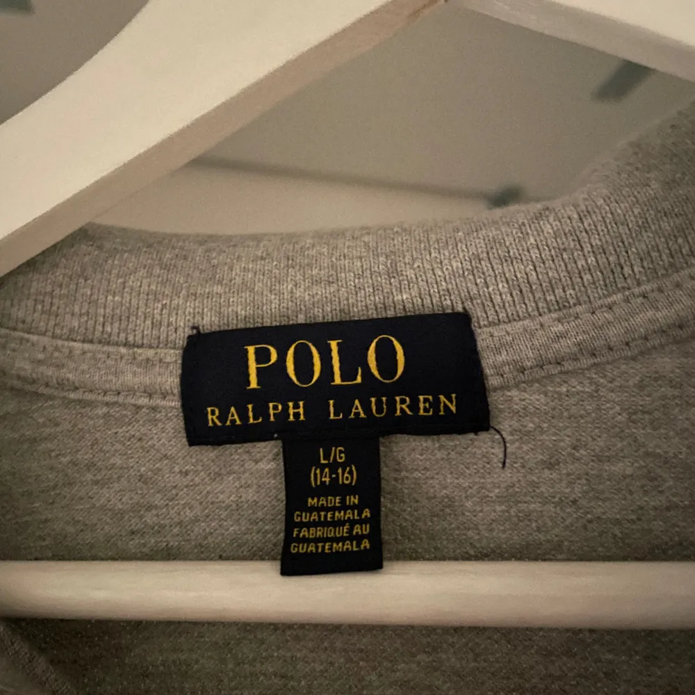 Grå Långarmad Polo Ralph Lauren Piké. Plagget är i använt fint skick. Storlek 14/16. Ny pris 950. Mitt pris 300.  OBS! Plagget är ganska liten i storleken.. Tröjor & Koftor.