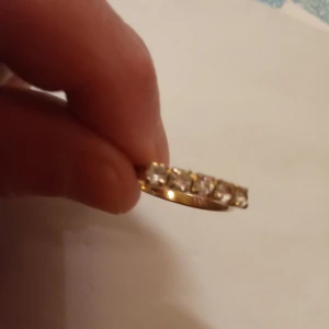 Ring guldfärgad med vita stenar jysterbar . - Ring guldfärgad med vita stenar och jysterbar .