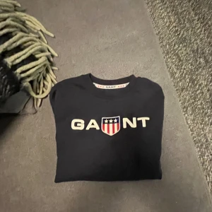 Gant collegetröja blå i tjejmodell stl 146-152 - Gant collegetröja tjejmodell stl 146-152 säljes för 250kr. Fint skick men fettfläck på ena armen (ej försökt att ta bort).