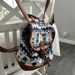 Liten ryggsäck  - Säljer min söta lilla ryggsäck pga kommer inte till användning. Knappt använd! Ni ser på sista bilden hur stor den är jämfört med min hand