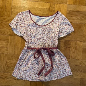 Vintage blus - Supersöt vintage blus i blommönster. I perfekt skick. Kan öppnas med dragkedja på sidan och knytas i midjan. Kommer aldirg till användning längre tyvärr 💗