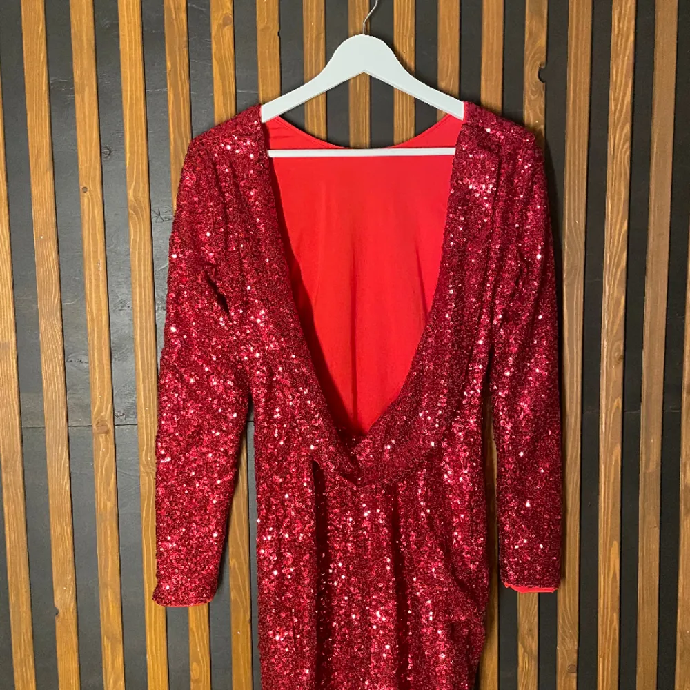 En röd paljettklänning men en djup urringning i ryggen, klänningen är i mycket bra skick! (Den ligger ut på fler sidor, så köper någon den innan så går jag på det). Klänningar.