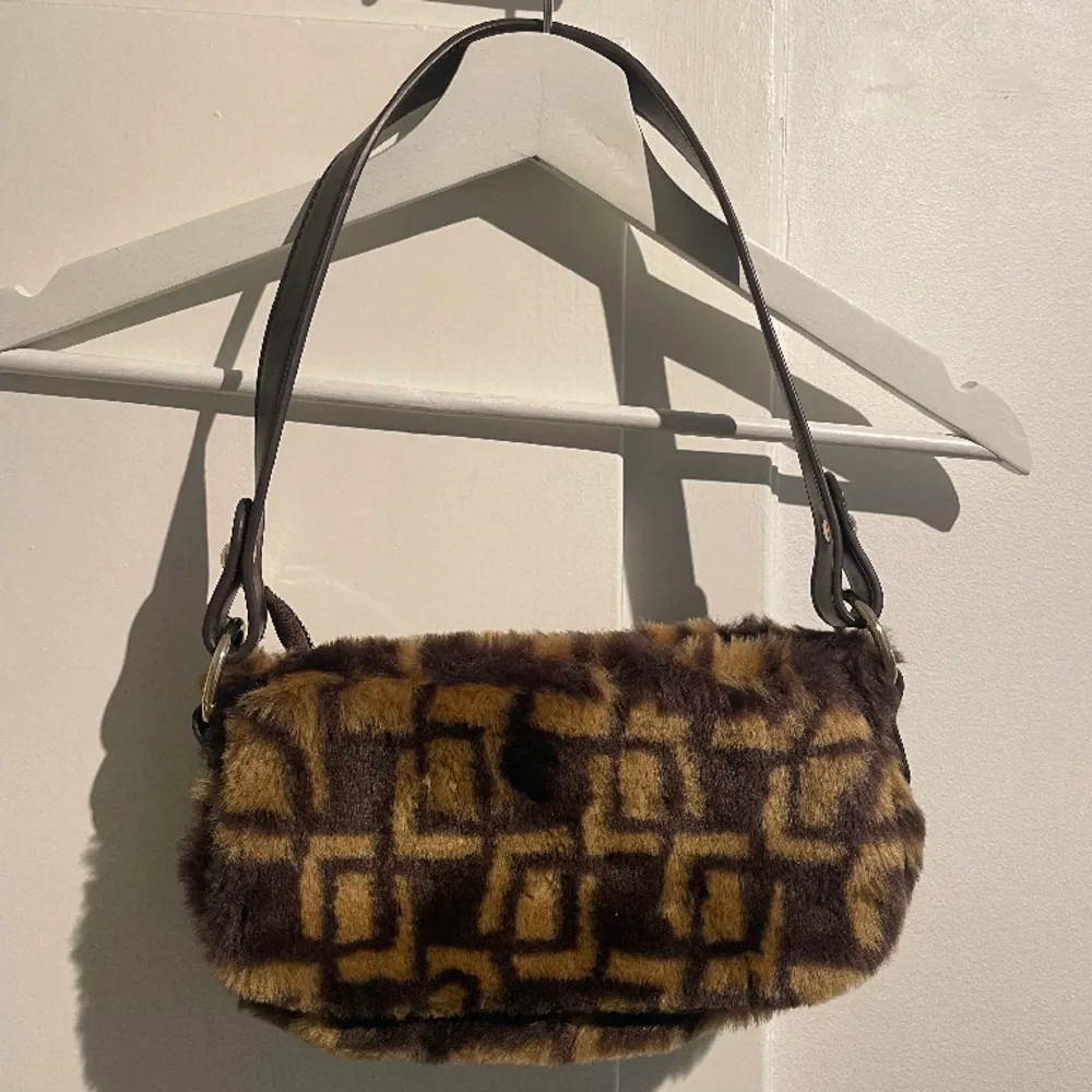 Handväska från Asos design i Y2k stil. Brun faux fur på utsidan av väskan. Använd fåtal gånger. 1 innerfack. . Väskor.