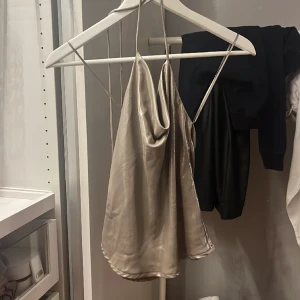 Festlig topp med öppen rygg - Fest topp från Gina Tricot. Köpt för 2 år sedan men otroligt bra skick. Öppen i ryggen med hängande band som man knyter i nacken!🥰