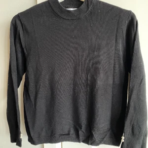 Svart finstickad tröja tjej strlk 152 - Svart tunn stickad tröja från Zara. Fin detalj med två vita pärlor vid varje ärmslut. Storlek 152. Rök- & djurfritt hem. 