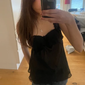 Svart spets topp  - Skit snygg svart spett topp,perfekt till fester🥂!, säljer då den är lite för lång på mig(är 158) den är i ny skick och kommer med en insydd bh,super praktiskt och skönt.☺️köparen står för frakt 📦❤️pris går att negociera 