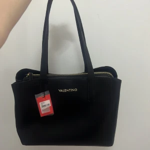 En Valentino väska - Valentino bag COUS bag Nero horse a spella VBS6MN01 med mått 35 x 28 13.5 cm. Helt ny och oanvändbar, jag har bara haft den åt sidan för har aldrig haft på mig den. Pris kan förhandlas. 