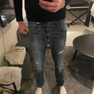 Slim jeans med slitningar och snygg tvätt och färg. Midjemått rakt över: 42,5 Hela byxans längd: 110 cm Mått över lår: 25 cm Hör av er vid frågor!! 