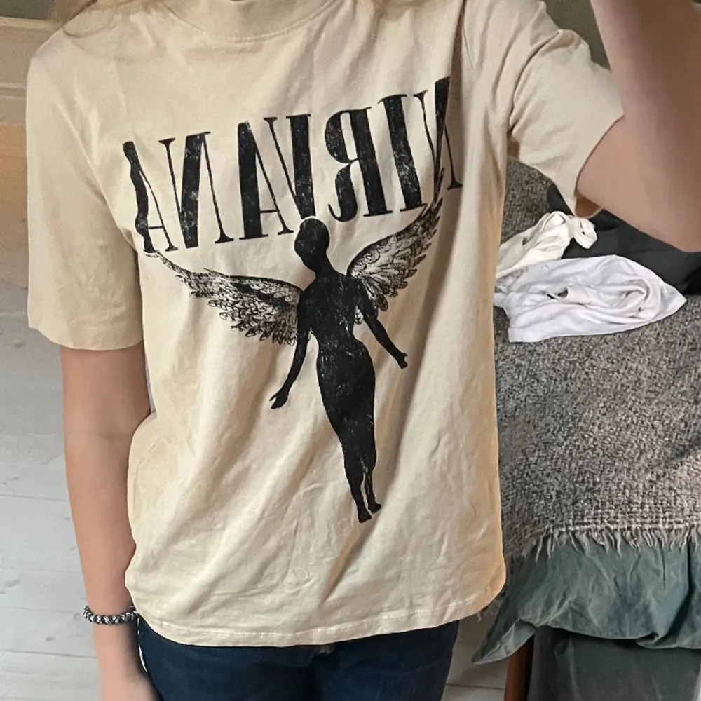 Säljer denna helt oanvända nirvana t-shirt från h&m! Den är i storlek xs. Jag har aldrig använt den därmed är den i perfekt skick utan några defekter eller hål! ☺️💓. T-shirts.