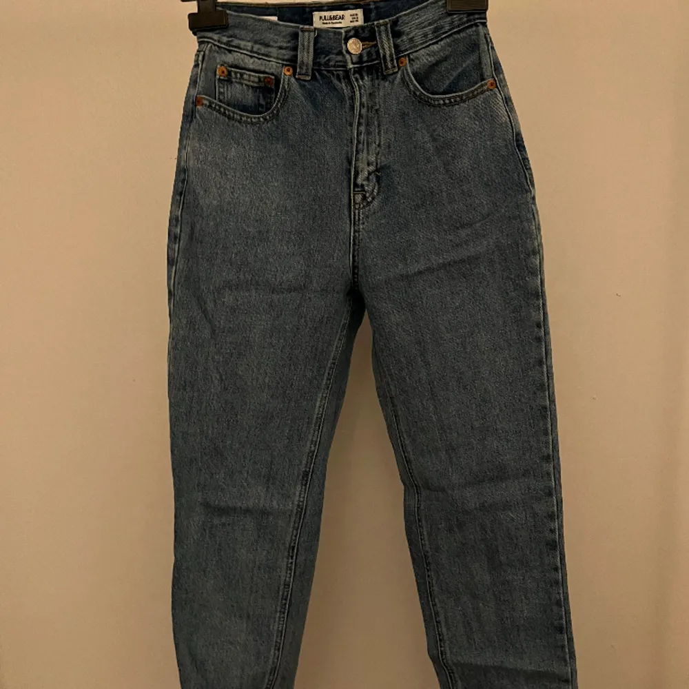 Mom jeans köpta från pull & bear med vita flammor på ena bakfickan. Endast använda ca 3 gånger men de matchar inte min längd men de ser jätte bra ut när de sitter rätt. Orginalpris 299kr. Jeans & Byxor.