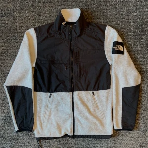 The North face vit fleece - Har ett litet hål där fram annars är den i väldigt fint skick många fickor med Resårband vid midjan stl S 