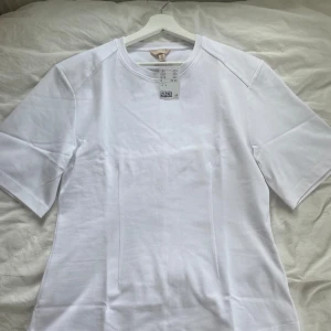 *Helt ny* vit topp med intagen midja från H&M - Vit topp med intagen midja från H&M i storlek M. Helt ny, prislappen finns kvar. Orginalpris: 429kr.