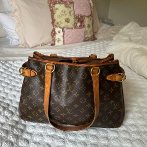 Louis Vuitton väska - Så fin väska från Louis Vuitton, använd men i bra skick. (Några små defekter förekommer se bilder)  Köpt på Vestiaire Collective  Orginalkartong finns att tillgå.  Perfekt för skola/jobb (dator 13 tum får plats)