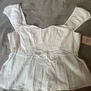 vit sommar topp från Nelly  - aldrig använd och lappen kvar går att knyta få den sitter fint runt midjan