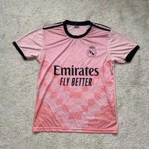 Real Madrid Jersey - Väldigt bekväm och snygg det står L men passar mig som har S och även M. Inget tryck bakom ryggen.