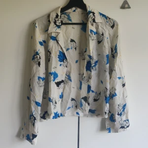Tunn blus - Tunn blus i unikt mönster. Köpt second hand, tror den är egensydd. Har ingen lapp men skulle tro att det är en small. Men passar nog båda xs och M beroende på hur man vill att den sitter.
