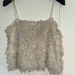 Festligt linne - Festligt linne med ”fluff” i färgen creme vit/ ljusbeige. Endast använd 1 gång och varan är i nyskick. Från Vero Moda i storlek M. 🤍