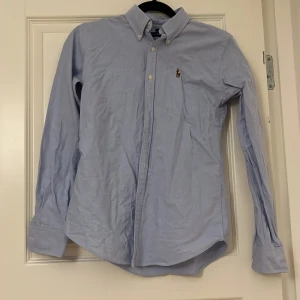 Skjorta - Skjorta från Ralph Lauren i Slim fit. Köptes i USA för många år sedan så den är i storlek 4. Endast använd på fina tillfällen så den är sparsamt använd och säljer den nu för att den bara hänger i garderoben och tar plats ☺️