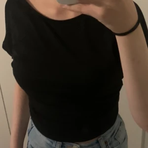 Svart topp. - Det är en fin svart topp med öppenrygg i storlek S. 