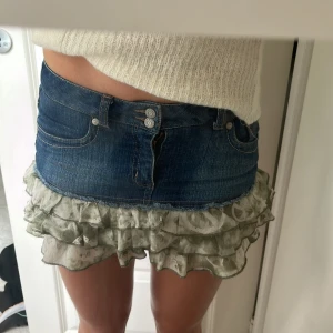 Kort jeanskjol med volanger  - Säljer nu denna superfina kjol då den tyvärr blivit lite liten 🩷i superbra skick med innershorts🩷 midjemått - 34, passar oxå 37( tvärs över) längd - ca 33 Mina egna bilder❣️