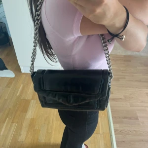 Väska  - Glansig väska med silverkedja. Väskan är från mango och är i nyskick!! Hör av dig vid frågor<3 