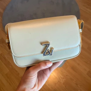 Zadig & Voltaire väska - Säljer nu min älskade Zadig & Voltaire väska som jag säljer då den ej används längre då jag köpt ny. Den är i bra skick, finns små repor men ej något man tänker på. Den grön/beige med bruna detaljer. Köpt från nk i Göteborg. Nypris 4000kr