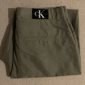 Calvin klein byxor - Kostymbyxor i khaki/grön/olive färg i jätteskönt material. Aldrig använt. Glömde helt enkelt att den existerade och tyvärr passar den mig inte längre i strl! 