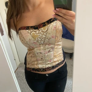 Festtopp - Sjukt snygg och unik festtopp som inte kommer till användning. Den är som en korsett och knäpps i ryggen med meshtyg i sidorna. Sjukt unik och snygg💗