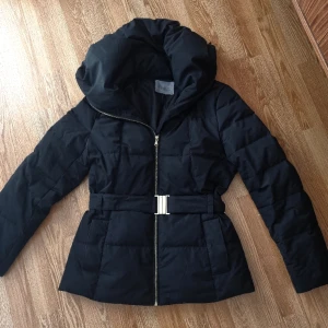 Pufferjacka m. avtagbart skärp - Varm och sitrer väldigt smickrande på kroppen.