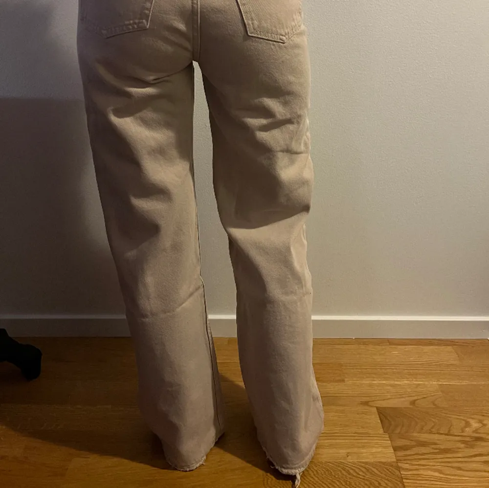 Ett par beige monki jeans som är baggy. Lite slitna nere vid fötterna.  Midjemått - 35cm Längd innerbenet - 76cm. Jeans & Byxor.