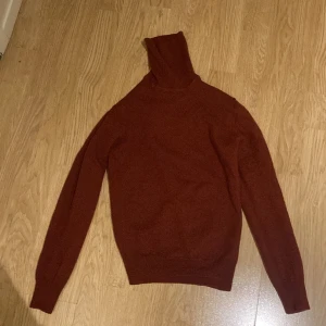 Stickad polo-tröja - Det är en stickad polo-tröja från J.Lindeberg. Den är vinröd. Tröjan är i storlek S. 