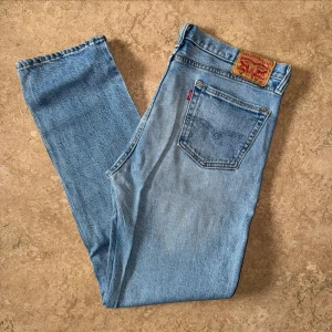Levis 511 Blåa Jeans - Levis jeans i modellen 511, använda men i gott skick. Storlek: 34 W, 32 L, Midja: 46.5 cm Ytterben: 109.5 cm Benöppning: 18.5 cm