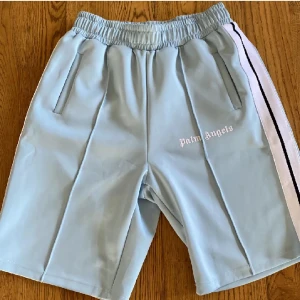 Palm angels shorts - Ett par riktigt snygga Palm angels shorts i färgen baby blue perfekt nu till sommaren. Skicket är i 10/10 knappt använda och helt fläckfria. Storleken är i S och passar även i M eftersom dom e långa dom e 54cm långa. Ifall det är något bara hör av di