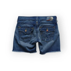 Blå jeansshorts från True Religion - Säljer ett par blå jeansshorts med ovanlig modell från True Religion i storlek W25 (XS). Midja 38 cm, längd 35 cm. Fråga gärna om fler bilder eller mått 💞