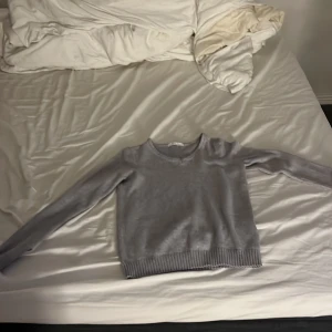 Grå stickad tröja - Säljer en mysig grå stickad tröja i storlek xs. Tröjan har långa ärmar och ribbstickade muddar vid ärmslut och nederkant. Perfekt för höst och vinter! 🧶