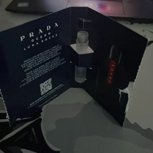 Prada Luna Rossa Ocean - Säljer en provflaska av Prada Luna Rossa Ocean parfym. Flaskan är liten och genomskinlig med en sprayapplikator. Förpackningen är mörkblå med vit text och har en elegant och modern design. Perfekt för att testa doften innan du köper en större flaska!