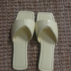 Beige sandaler med fyrkantig tå - Säljer ett par snygga ljusgula sandaler med fyrkantig tå. har en enkel men stilren design. Perfekta för sommaren och passar till både vardag och fest. De är i nyskick och har en normal passform.