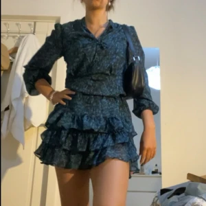 Klänning - Säljer denna så snygga volangklänningen! I nyskick och endast använd ett fåtal gånger. Obs. brukar vika upp klänningen i midjan som på bild 1, se bild 2 för verklig längd.❤️☺️