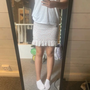 Blommig kjol - storasysters gamla, inte använd alls mycket av nån av oss!🩷 inga defekter alls, super fin!!!🤗 storlek 34/xs men då kjolen är stechig funkar kjolen bra som 36/S och 38/M också!💞säljer då jag aldrig använt den☺️ fint mönster, se bild 3. Frågor? Skriv!🫶🏻🫶🏻