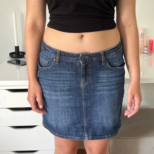 Jeans kjol - Blå jeans kjol som sitter mid waits på en person som är 168