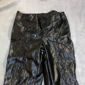 Läder byxor med snörning - Byxor i fejk läder/latex men justerbar snörning, från Beyond retro i toppen skick