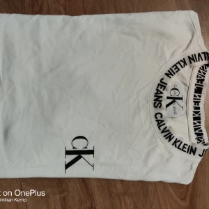Calvin Klein T-shirt  - Dam T-shirt av märket CK. Storlek xs finns en gul fläck som knappt syns därav priset annars jätte fräsch T-shirt. Kolla även andra annonser för helt nya produkter. Mvh Streetlyxkollektionen 