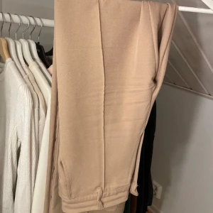 Kostymbyxor - Beige rosa i färgen. Mid waist. Från madlady