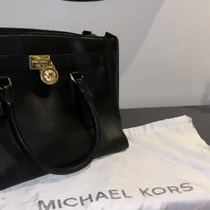MK (Michael Kors)  - En fin och rymlig väska i svart läderfärg med guldiga detaljer från micheal kors. Det är en äkta väska från MK med påsen till väskan. Betalade ungefär 3000kr och den är i bra skick. Jag säljer för 1800 + frakt 📦 