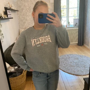 Tröja - Grå tjocktröja med ett vit och orange tryck på bröstet🩶🤍🧡