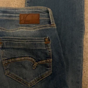 Blåa Mavi jeans🩵 - Dessa underbara jeansen är från Mavi och har en jätte unik design på fickan. De är lite slitna längst ner men har fortfarande samma längd. Innerbenet:84cm midjan:36cm. Nypris:600kr.🩵