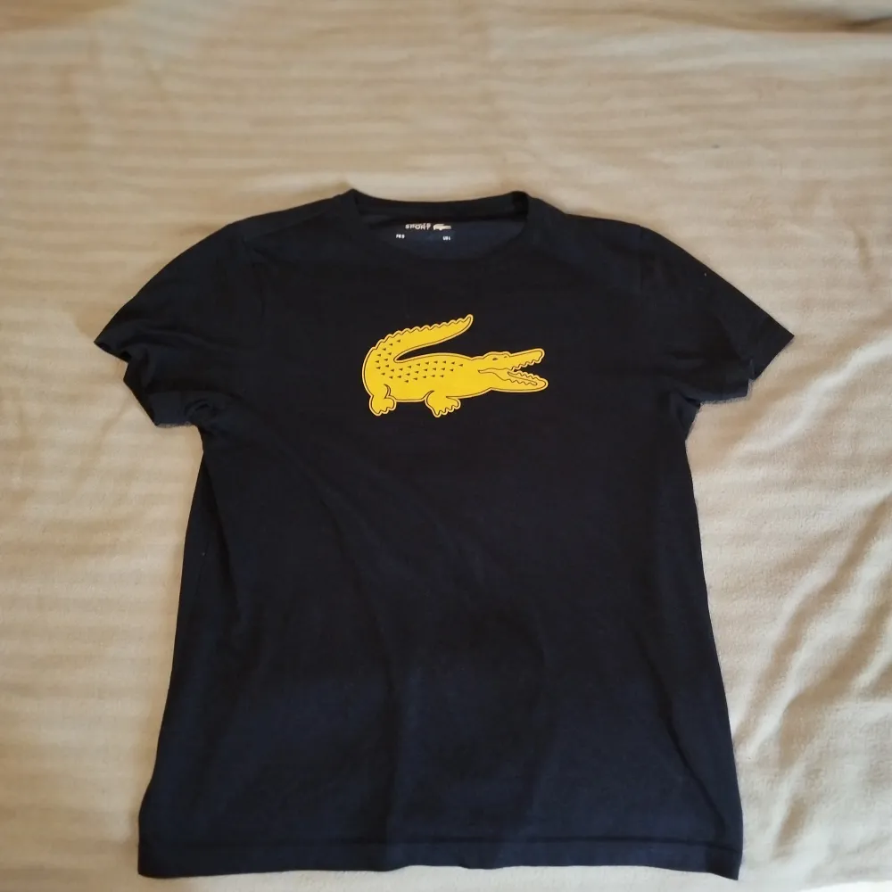 Säljer en helt oanvänd Lacoste tshirt i storlek L, mörkblå med en stor synlig krokodil på bröstet, tröjan är precis som du köpt den, inte en endaste spricka på bröstet, märken, fläckar osv (har enbart testat den). T-paidat.